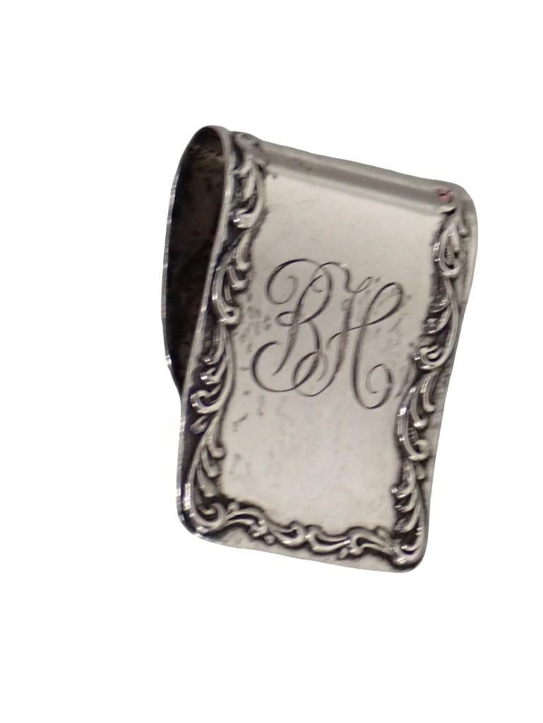 An S. Kirk & Son Sterling Silver Napkin Ring Clip. Script monogram "BH". Reverse is stamped "S. Kirk (1 of 8)