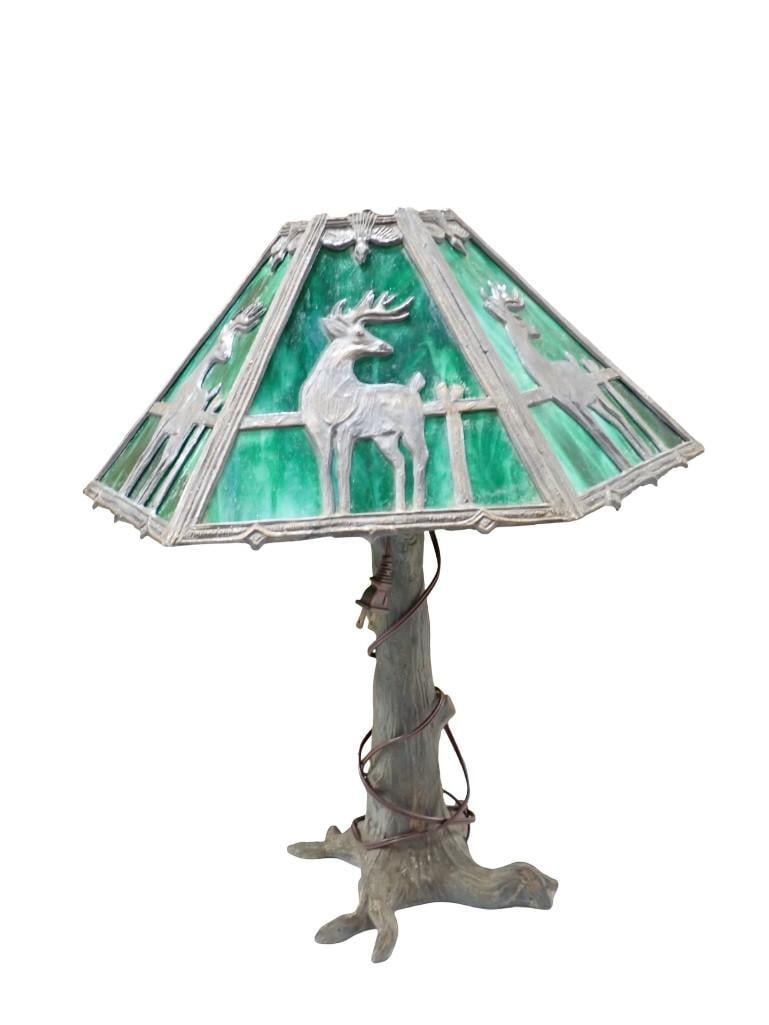 Stained Glass or Slag Glass Lamp Works: Stained Glass or Slag Glass Lamp. It works. Green with deer design. All pictures are considered part of the description and should be examined carefully by bidders. Live Auctioneers is n