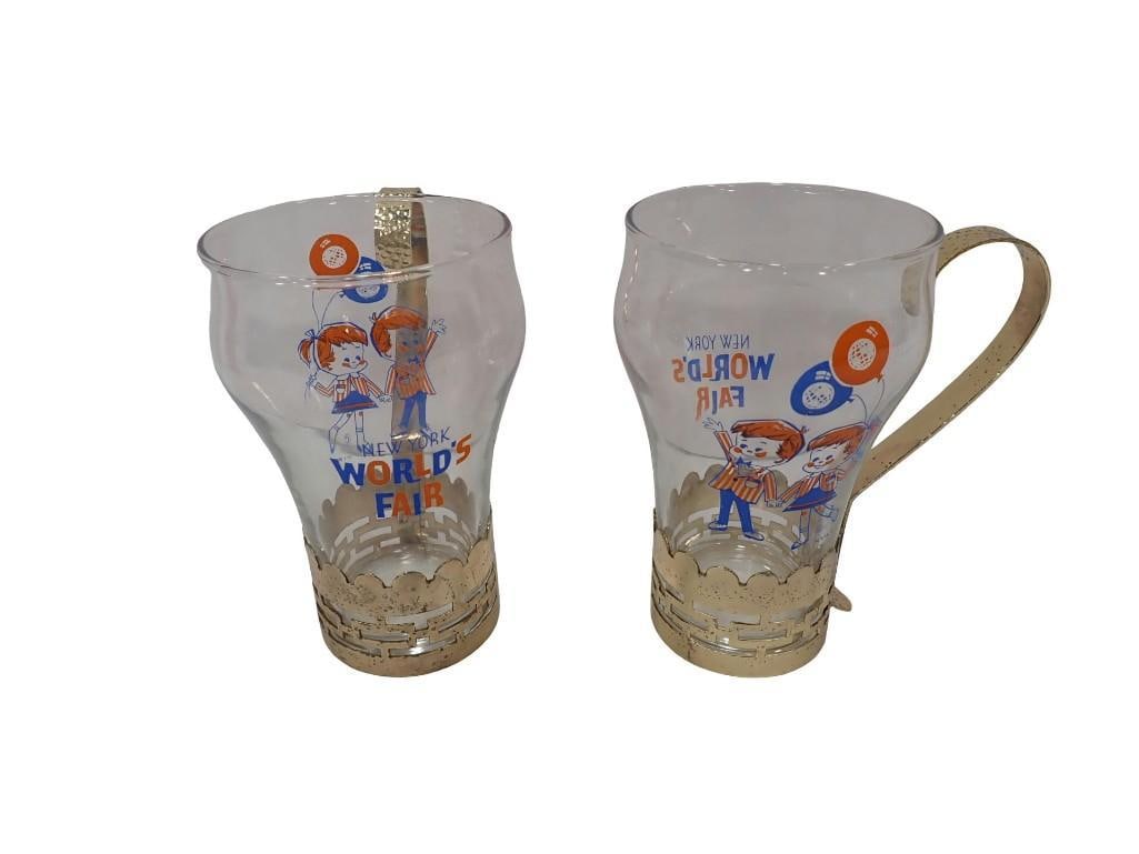 Two Vintage New York World's Fair 1964/65 Soda Cups / Drinking Glasses with Metal Base / handles: Two Vintage New York World's Fair 1964/65 Soda Cups / Drinking Glasses with Metal Base / handles All pictures are considered part of the description and should be examined carefully by bidders.