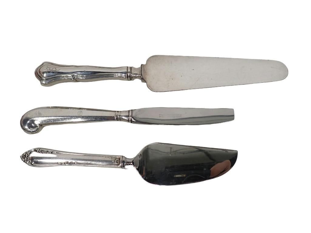 Group of Sterling Silver Handled Serving Pieces; including one Kirk Steiff knife in the Williamsburg: Group of sterling silver handled serving pieces; including one Kirk Steiff knife in the Williamsburg Queen Anne pattern (blade broken), one Reed & Barton cheese wedge in the Dancing Flowers patter