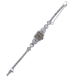 Hamilton Platinum Diamond Lady's Watch: Metal Content: Platinum. Dial: Signed Hamilton with dot gold tone markers. Case and bracelet decorated with diamonds. Weight of Item: 27.4 grams.Size: Case - 14mm x 19mm. Band - 6 1/8" long.