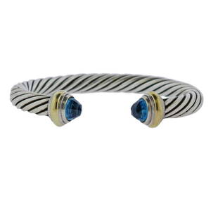 David Yurman 14K Gold Silver Blue Topaz Cable Cuff: Metal Content: 14k Gold, Sterling Silver.Weight of Item: 43 grams.Size: Bracelet will fit up to 7&quot; wrist, width - 7mm.Gemstone: Blue topaz.Stamp: 585 D. Yurman 925.