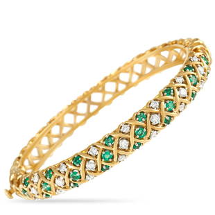 Tiffany & Co. Vintage 18K Yellow Gold 1.00 ct Diamond and Emerald Bracelet: An 18K Yellow Gold setting with a charming lattice pattern sets the stage for this impeccable bangle bracelet from Tiffany & Co. Perfectly poised, it comes to life thanks to 1.0 carats of glittering