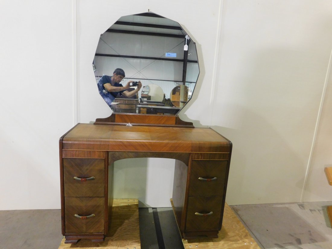 Waterfall Vanity with Mirror: Waterfall design vanity with kneehole and mirror, on wheels. 4 drawers with brass and bakelite handles. Approximately 44 inches wide, 66 inches tall, 18 inches deep. Overall good condition, light wear