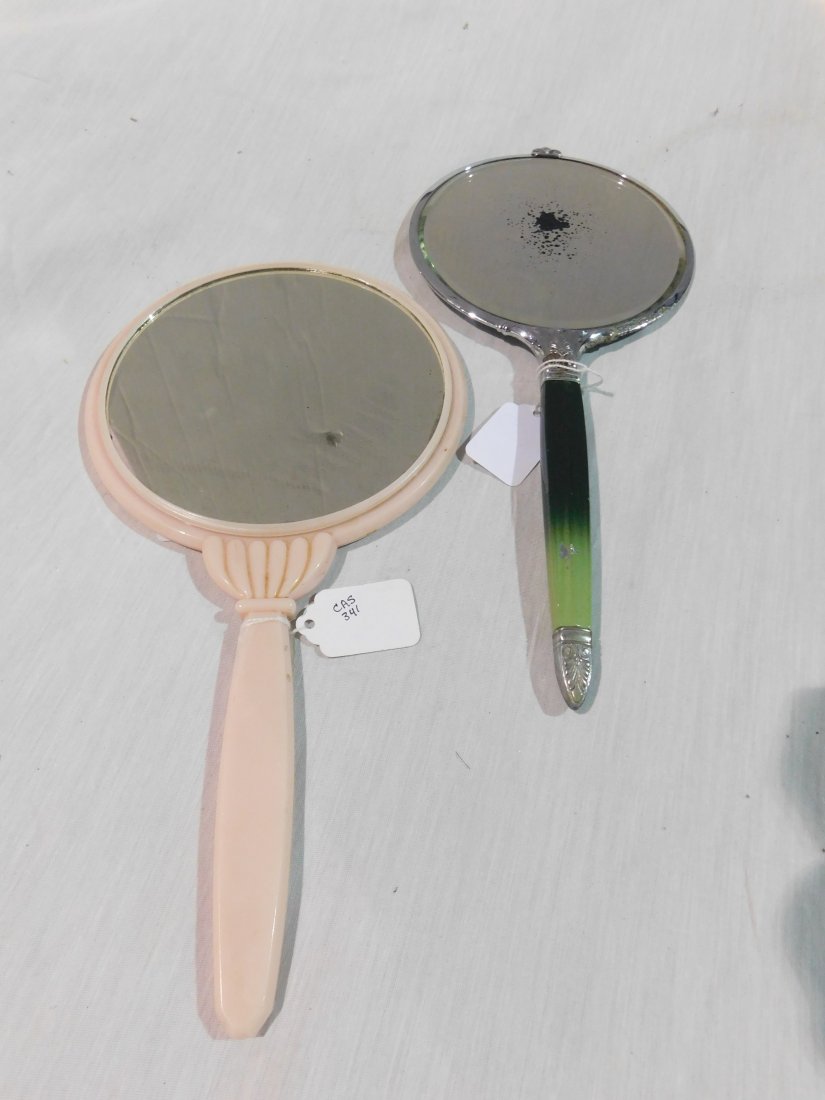 (2) vanity mirrors: 2 hand held vintage vanity mirrors, one green bakelite handle(some mirroring loss), one pink in good condition