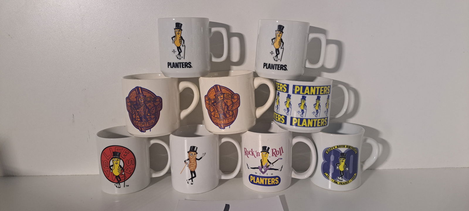 (9) Mr. Peanut coffee cups: Lot of 9 various ceramic coffee mugs with Mr. Peanut. All in good condition. Please note: if picking up, location is different than auction location. Please contact us for options