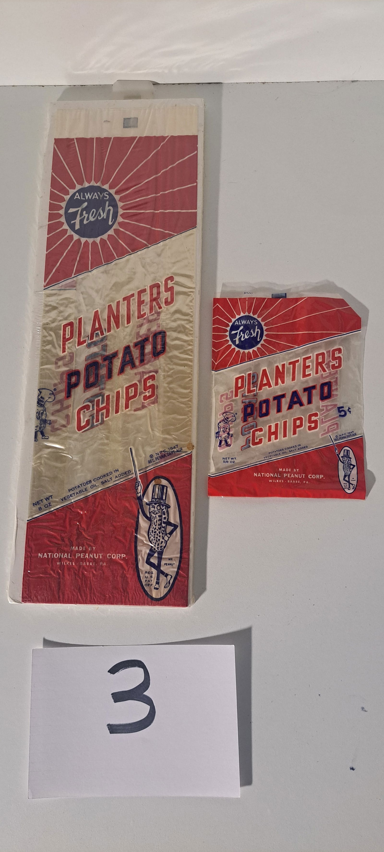 (2) Planters Peanut potato chip bags: lot of 2 different size, early, cellophane, Planters Peanut potato chip bags. one held 8 oz., one held 5/8 oz. Great graphics, very good condition, with 2 minor spots as shown on the larger bag.