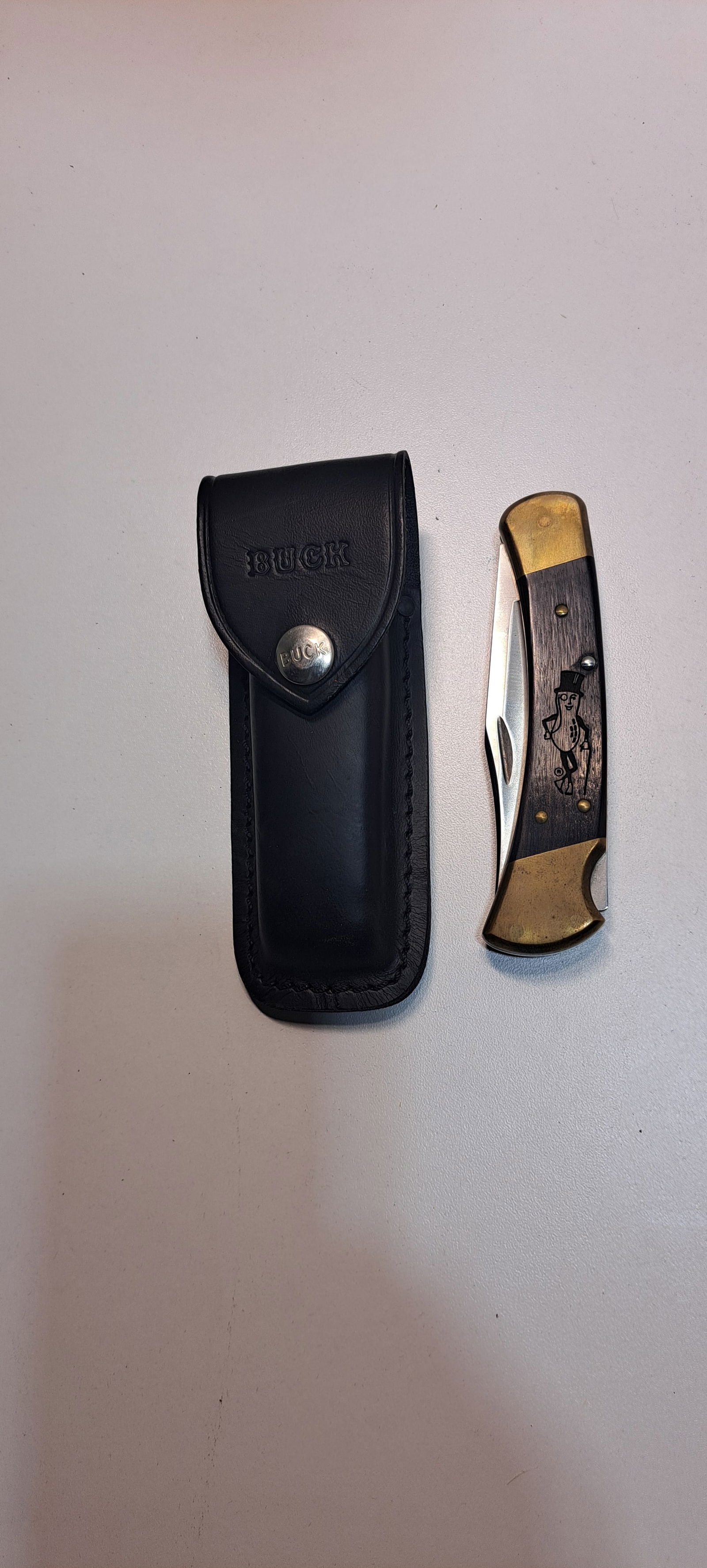 Mr. Peanut Buck knife: Buck pocket knife with leather sheath, wooden handles with Mr. Peanut carved in handle, excellent condition, approx. 5" long folded, Please note: if picking up, location is different than auction