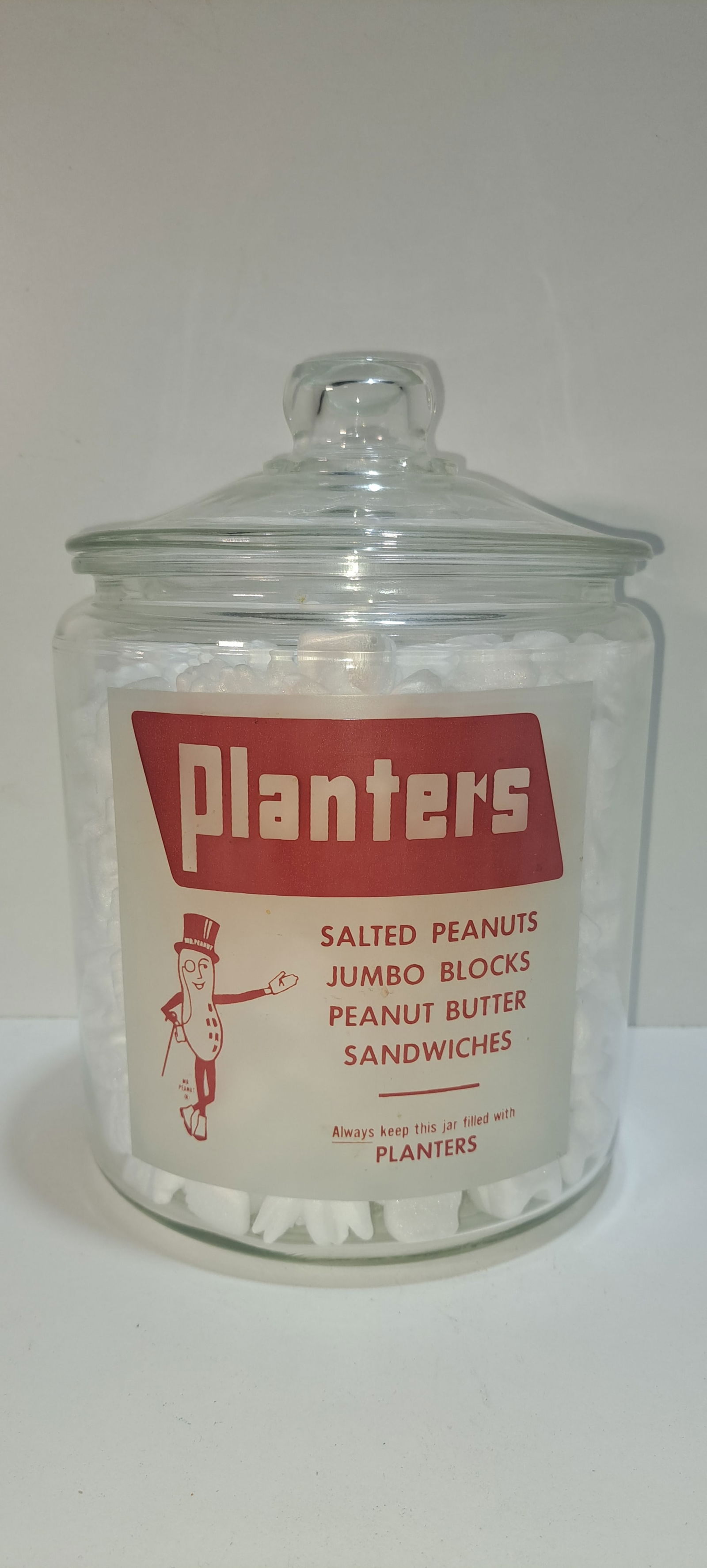 Planters Peanut glass counter jar: round Planters Peanut, clear glass counter jar with frosted label, correct lid, 4 products listed, excellent condition, no chips or cracks, approx. 7.25" diameter, 10" tall, Please note: if picking