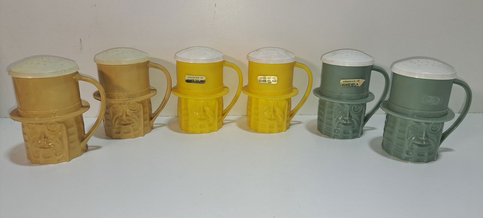 3 sets Mr. Peanut cup salt and pepper shakers: 3 sets of plastic, figural, Mr. Peanut cups with salt and pepper shaker tops, yellow, tan, and blue/gray, minor wear, each approx. 4" tall, Please note: if picking up, location is different than