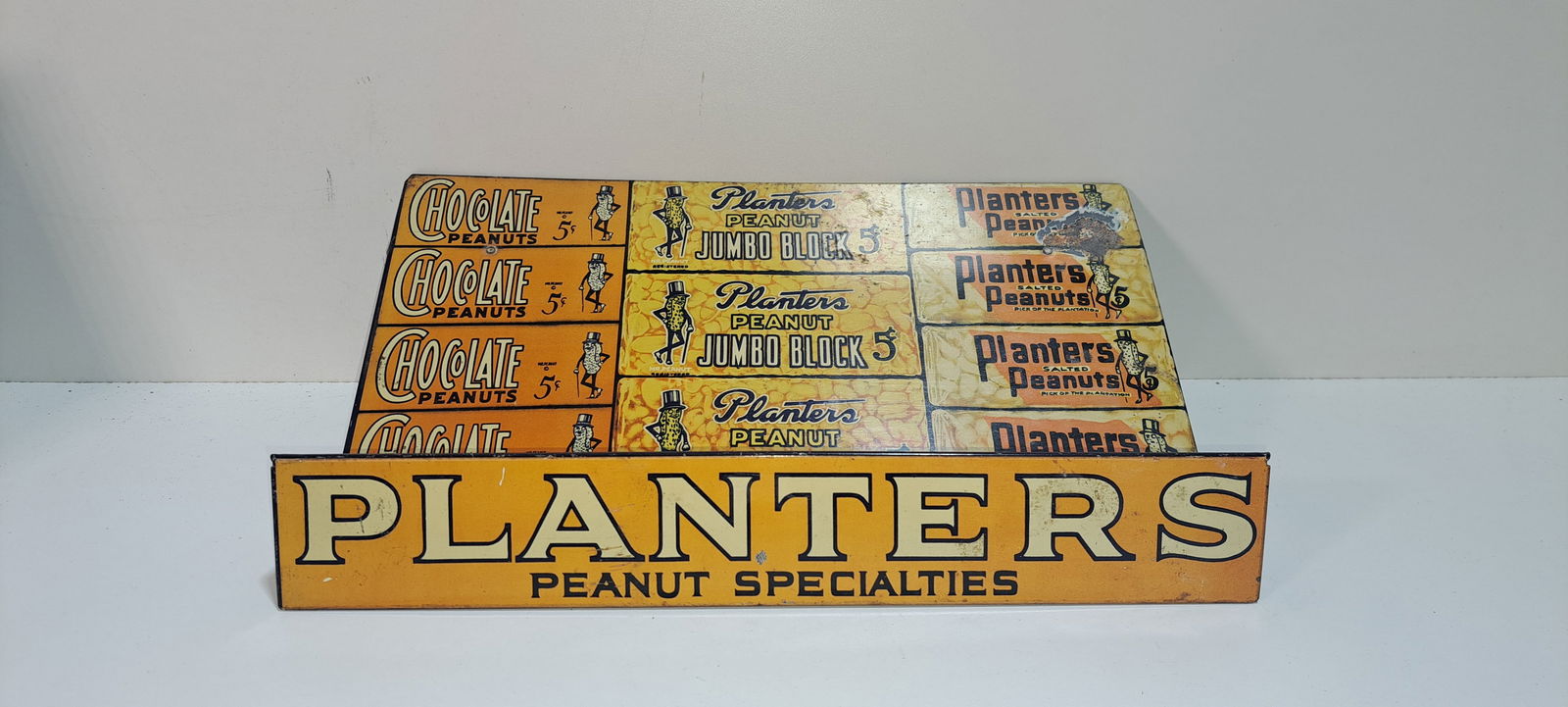 early Planters Peanuts tin display: early, Planters Peanuts, slanted tin display, held 3 different products, folding legs on back, shows some wear, otherwise nice, approx. 9" x 14" x 4.5", Please note: if picking up, location is differe