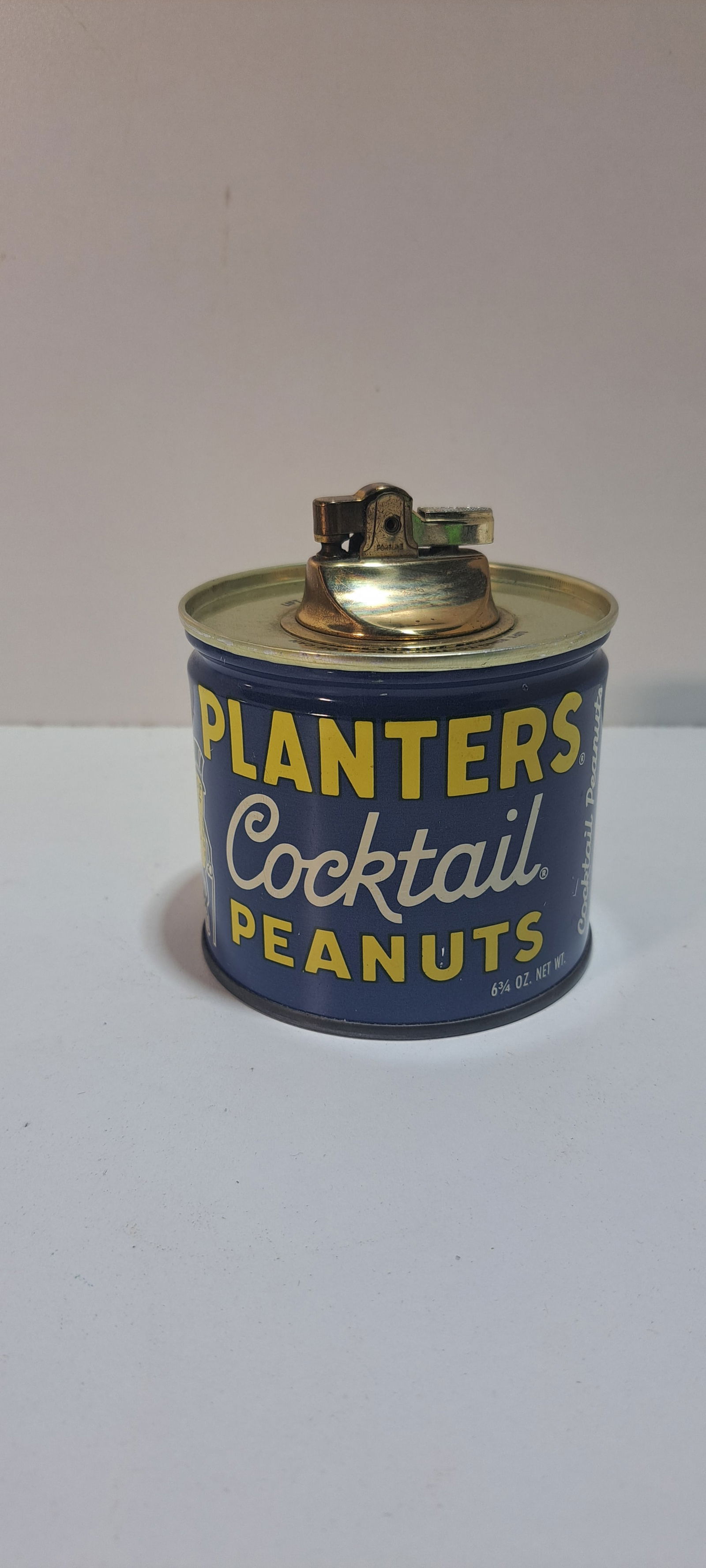 Planters Peanuts cocktail tin lighter: table lighter shaped like a Planters Peanut 6 3/4 oz. cocktail tin, good condition, approx. 3.75" tall, Please note: if picking up, location is different than auction location. Please contact us for