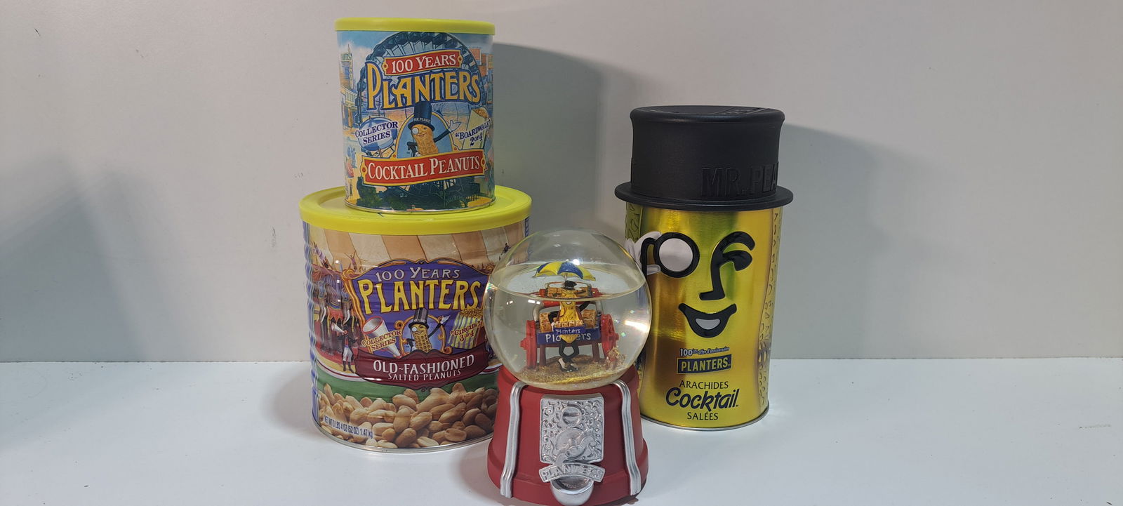 Planters Peanuts lot: Planters Peanuts lot consisting of: 3- 100 year anniversary tins, one with product sealed, 1- musical snow globe, appears to have small leak, still plays music, Please note: if picking up, location is