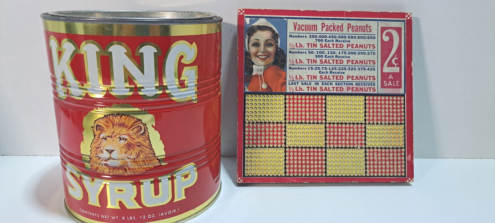 King Syrup tin, punchboard: King Syrup tin with lid, held 8 lbs., strong color, minor dent, approx. 7" tall, one 2 cent punchboard for peanuts, unpunched, with punch on back, minor wear, approx. 7.5" x 7.75", Please note: if