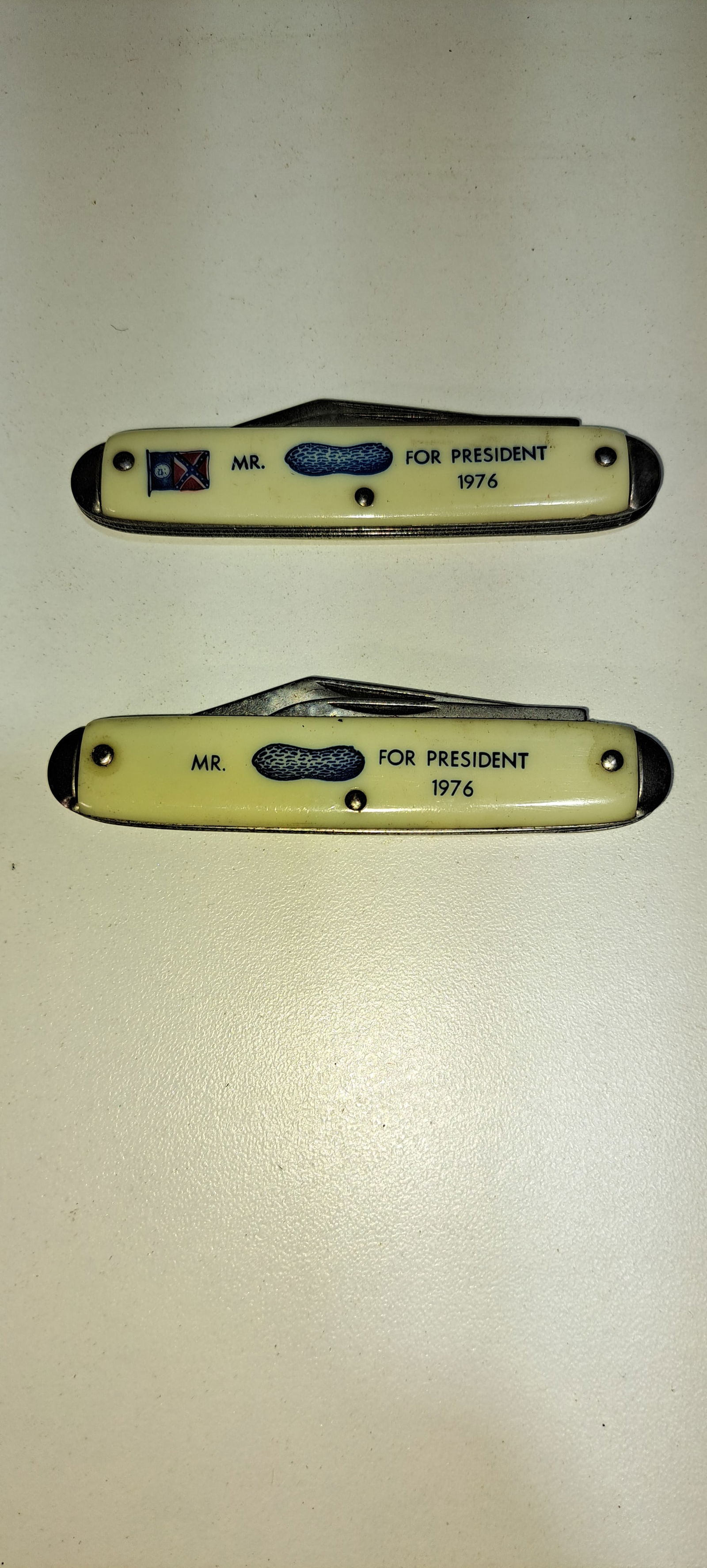 (2) Jimmy Carter pocket knives: 2 different pocket knives, Mr. Peanut(Jimmy Carter), for President 1976, one shows Dixie flag, both have 2 blades, good condition, approx. 3.5" long folded, Please note: if picking up, location is