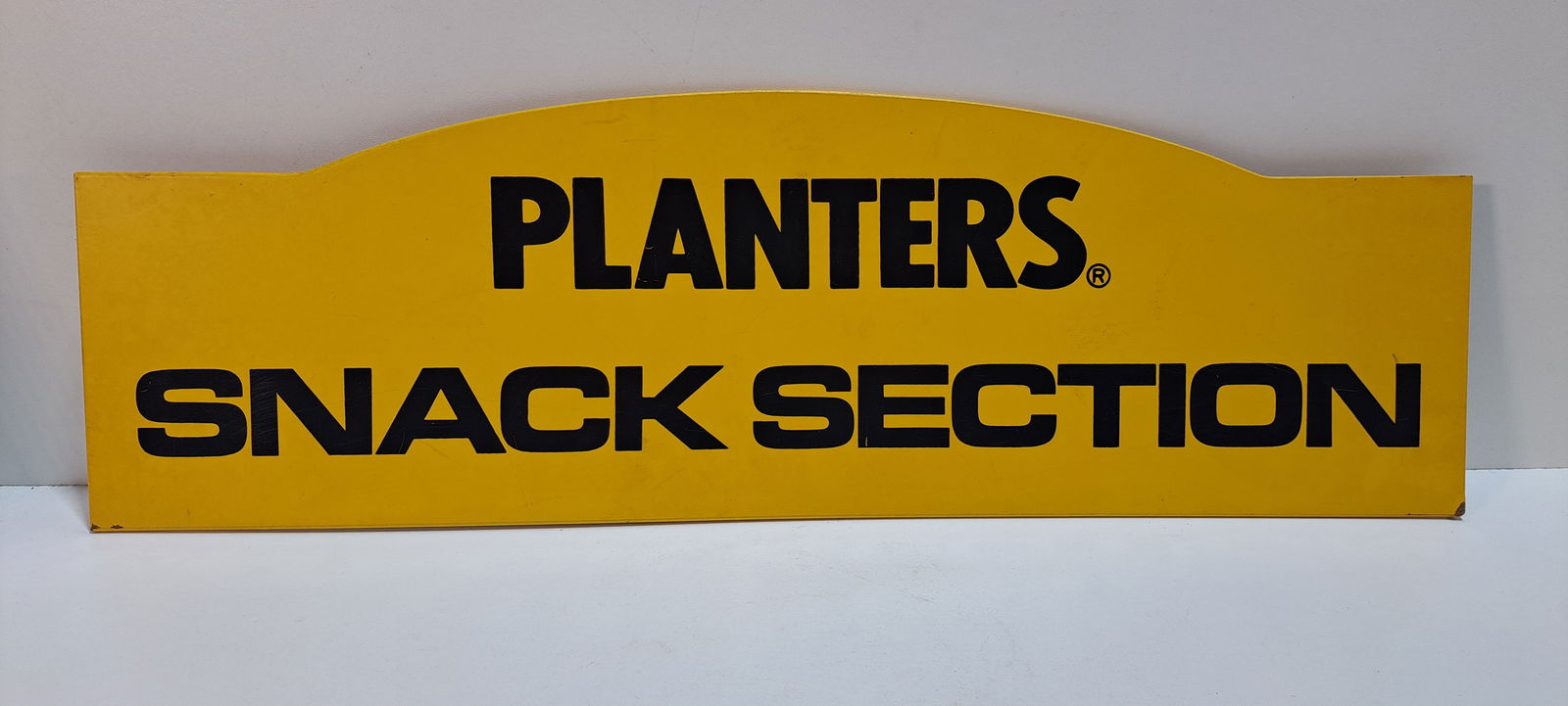 Planters Peanuts sign: Planters Peanuts Snack Section, single sided, masonite sign, shows minor wear, approx. 7.5" x 24", Please note: if picking up, location is different than auction location. Please contact us for option