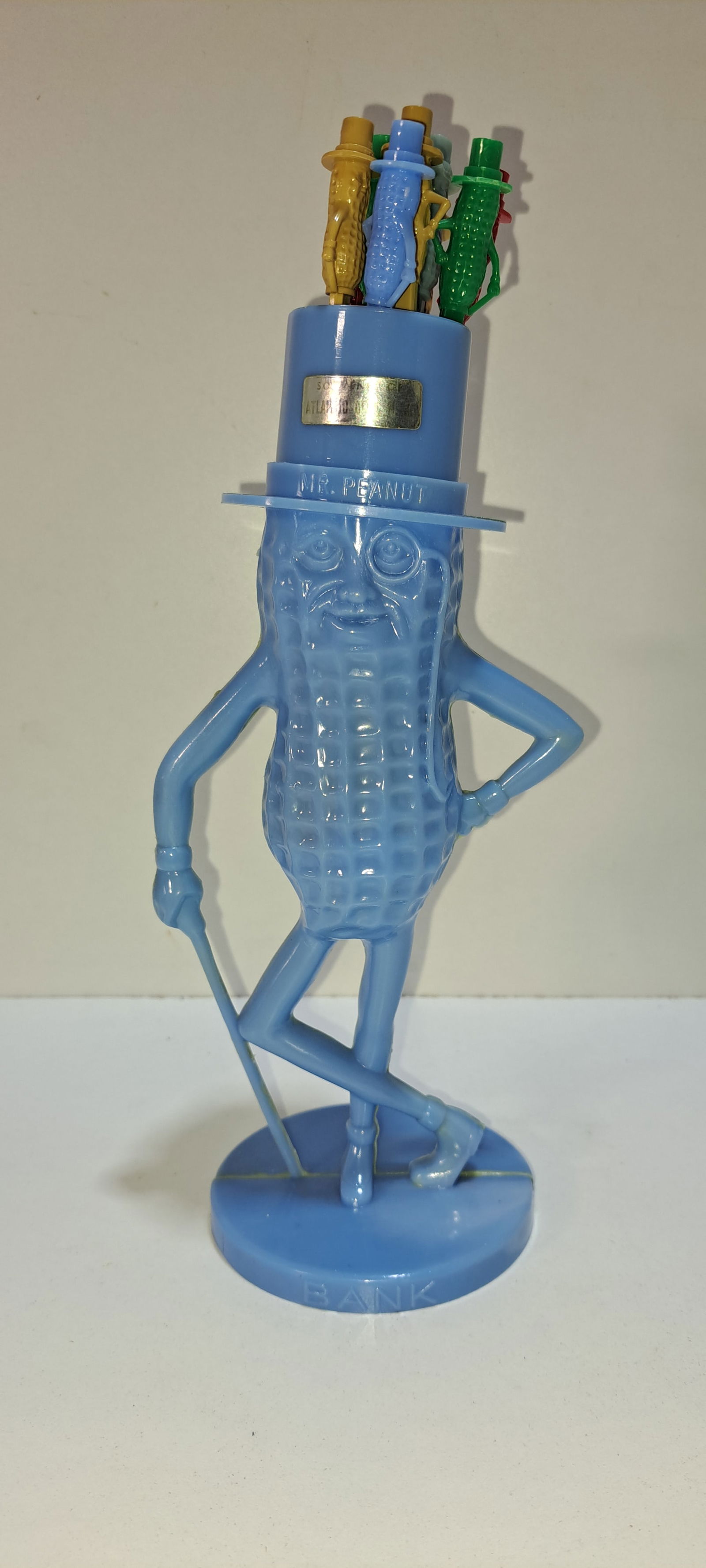 Mr. Peanut stirrer holder: light blue, plastic, figural, Mr. Peanut stirrer holder with 9 stirrers, faded souvenir sticker from Atlantic City, has mark on side of hat as shown, no other damage, approx. 8.5" tall, Please note: i