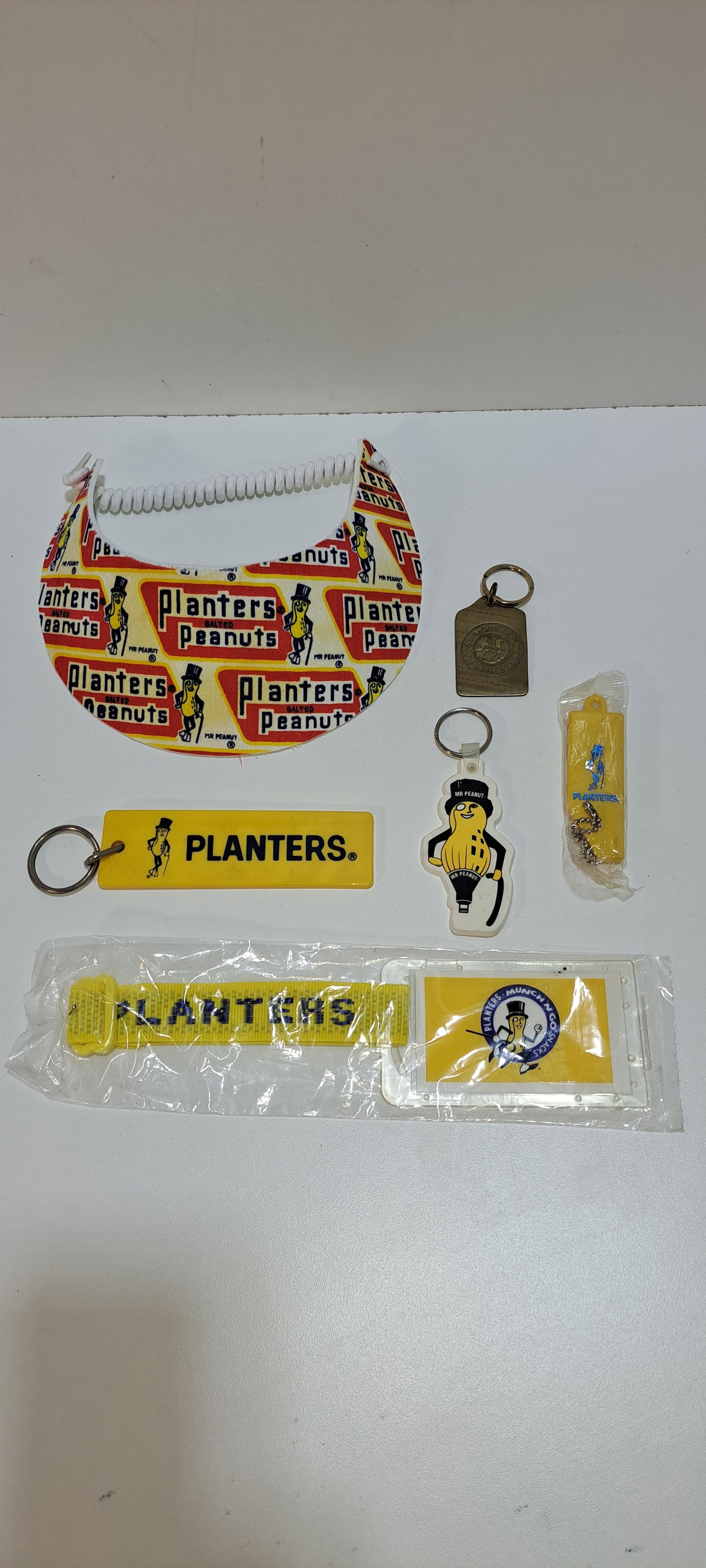 Mr. Peanut lot: Mr. Peanut collectibles lot consisting of: sun visor, and 5 different key chains, all in very good condition, Please note: if picking up, location is different than auction location. Please contact us