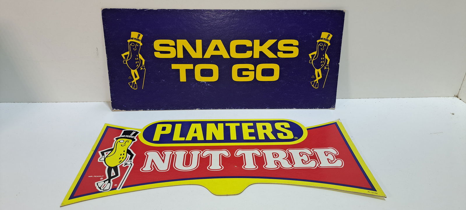(2) Planters Peanuts cardboard signs: 2, double sided, cardboard signs advertising Planters Peanuts, both with Mr. Peanut, both show some wear, strong colors, each approx. 7.5" x 17", Please note: if picking up, location is different than