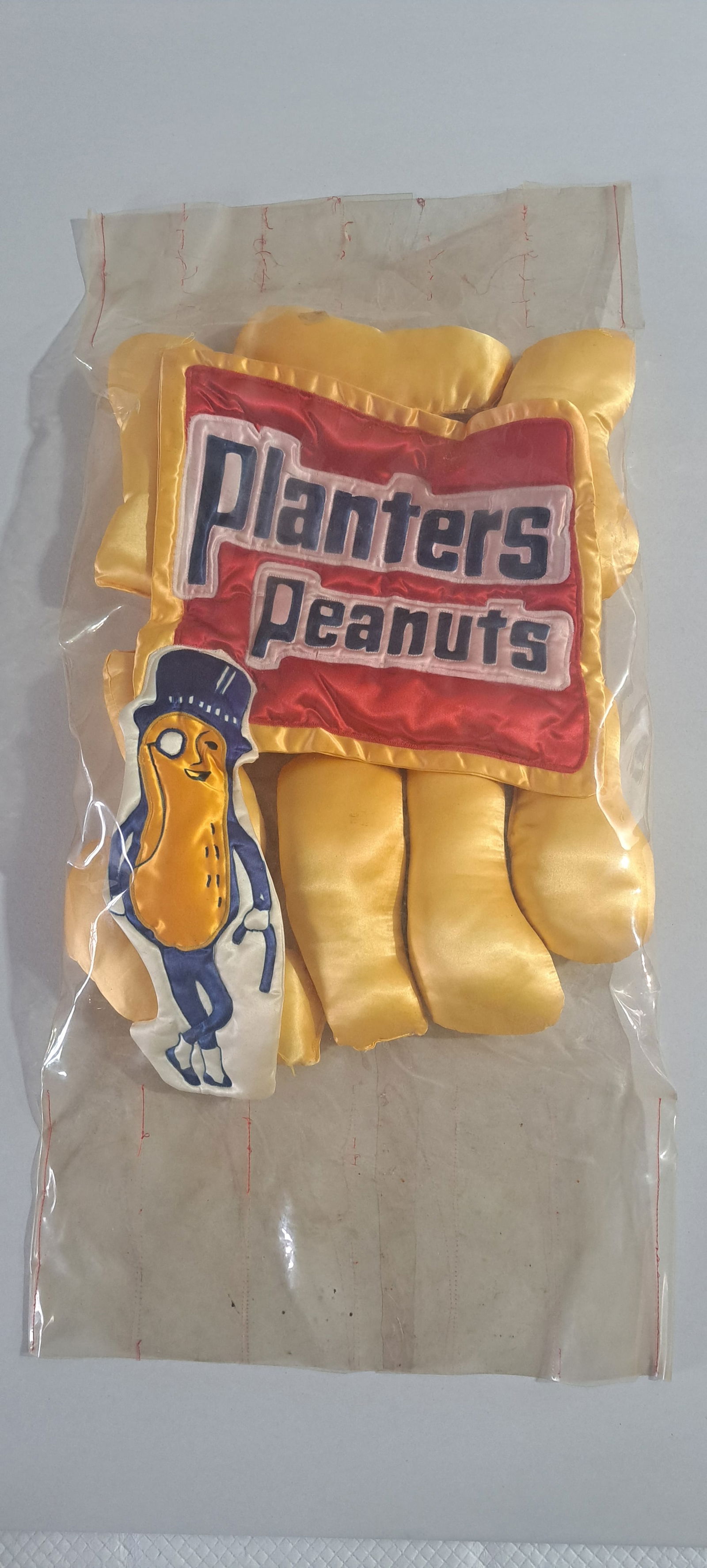 unusual Planters Peanuts display: unusual Planters Peanuts hanging display, outside is made of clear vinyl, inside, stuffed silk type material, made to look like a large bag of peanuts, this would have hung in a store, and dates