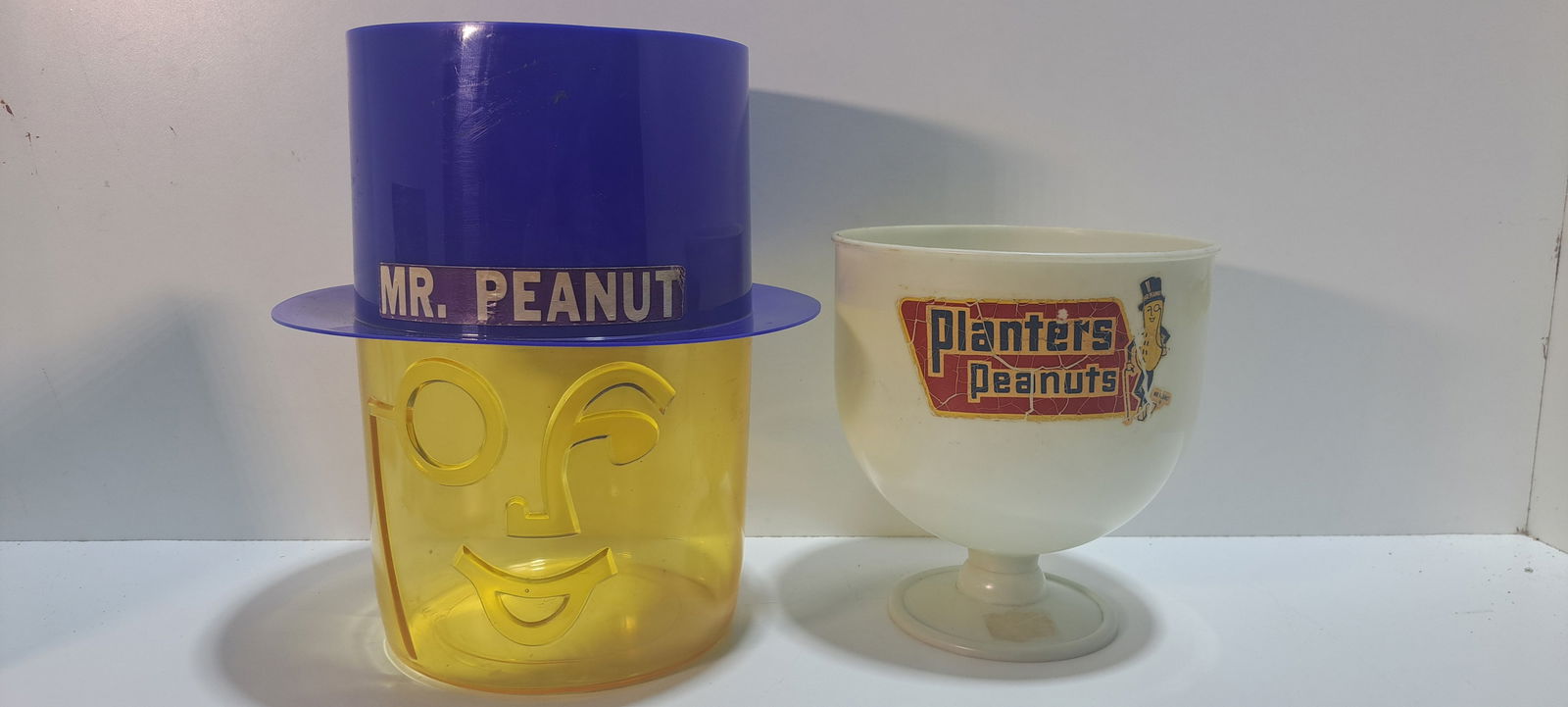 (2) Planters Peanuts display bowls: 2 Planters Peanuts, plastic, counter top snack bowls, one shaped like Mr. Peanut's head, good condition with minor wear, approx. 12" tall, one white pedestal bowl, with Planters Peanuts decal, shows s