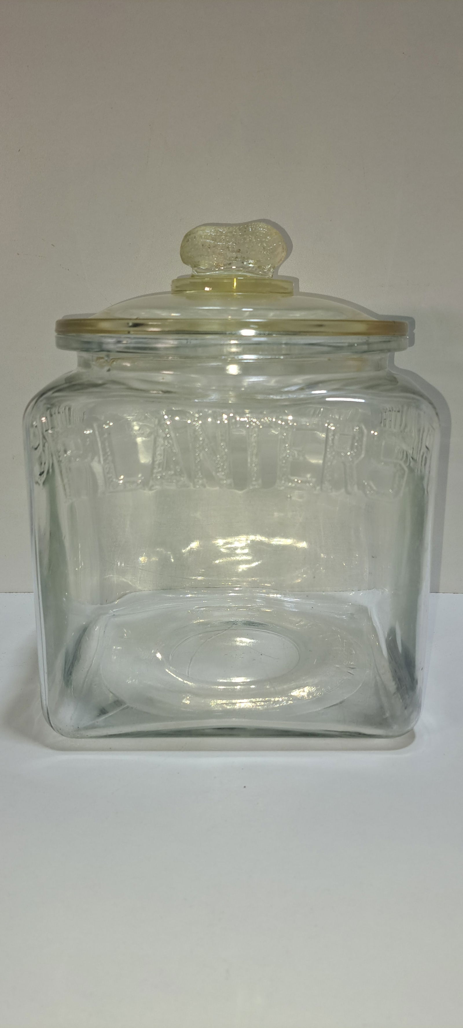 Planters Peanuts square jar: original, Planters Peanuts, clear glass, counter top jar, embossed PLANTERS on all 4 sides, correct lid with peanut shaped handle, minor roughness on inside of jar rim and lid, approx. 9.5" tall,