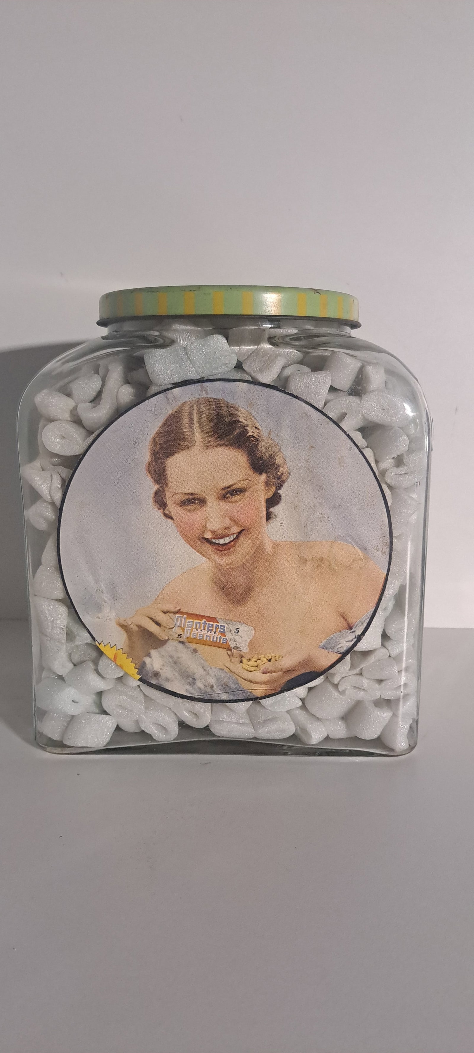 Planters Peanuts Leap Year glass counter jar: Planters Peanuts, glass counter jar with tin lid. Embossed PLANTERS diagonally on end, 1940 Leap Year on bottom. With correct pretty lady paper labels inside. This is an original jar, not a reproducti