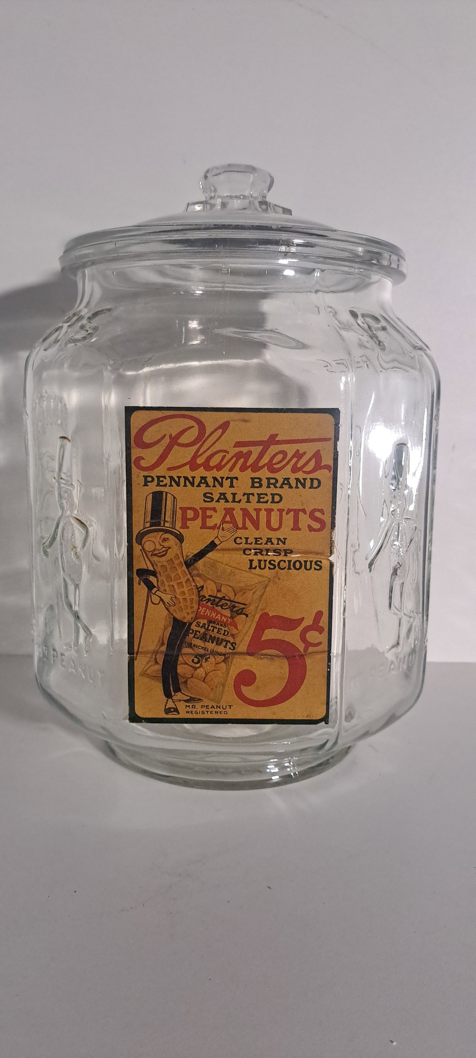Planters Peanuts 8 sided glass counter jar: Planters Peanuts 8 sided glass counter jar with nice original paper label. Original lid as well. Jar is heavily embossed with Mr. Peanut on 4 corners. This is an original jar and not a reproduction.