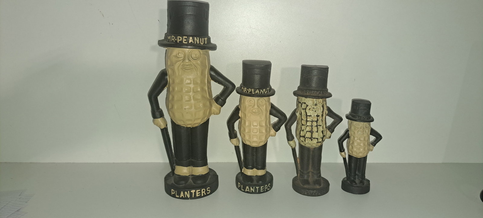(4) cast iron Mr. Peanut banks: Lot of 4 different size, cast iron, figural, Mr. Peanut coin banks. These were a fantasy item made in the early 90's. 3 in very good condition, 1 shows wear to paint. Approx. 5.75", 7.75", 8", 11.25",