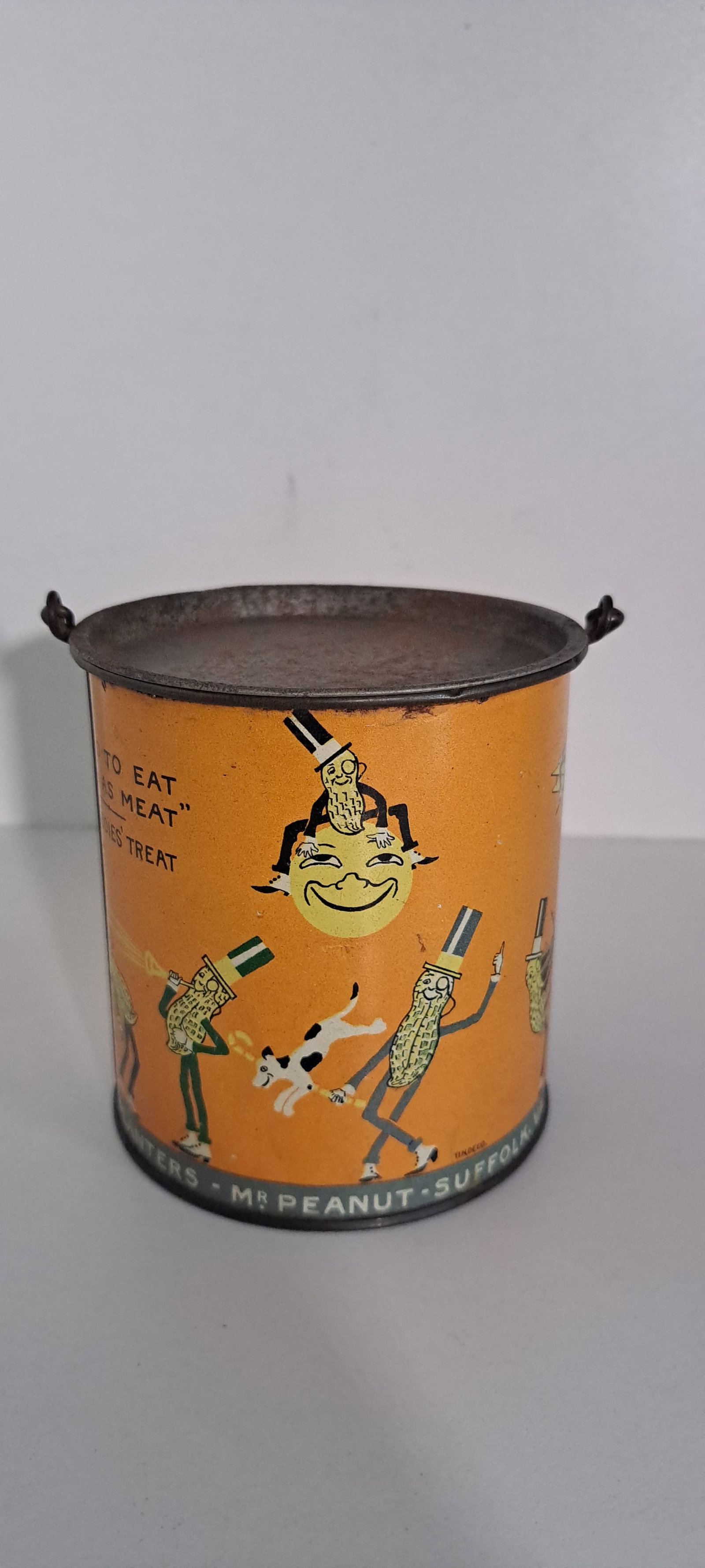 Planters Peanut 1lb. circus tin: Early, Planters Peanuts, 1lb. peanut butter tin. Showing multiple Mr. Peanuts doing various circus acts. Complete with lid and wire bail handle. Minor wear. overall very good condition. Approx. 4" tal