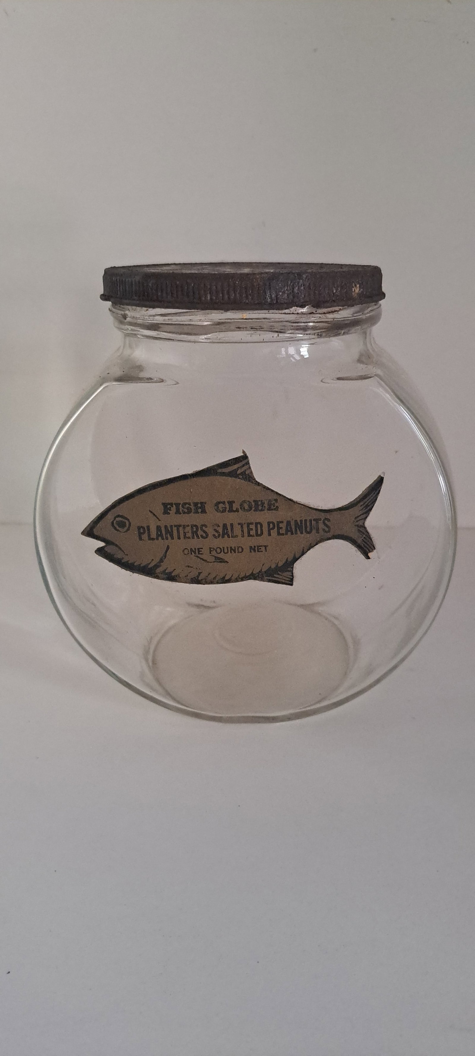 Planters Peanuts 1 lb. fishbowl jar: Early, Planters Peanuts, 1lb. fishbowl jar with fish shaped label. Has metal screw on lid. Includes, hard to find label on bottom side of the lid. This is an original jar, not a reproduction. Minor