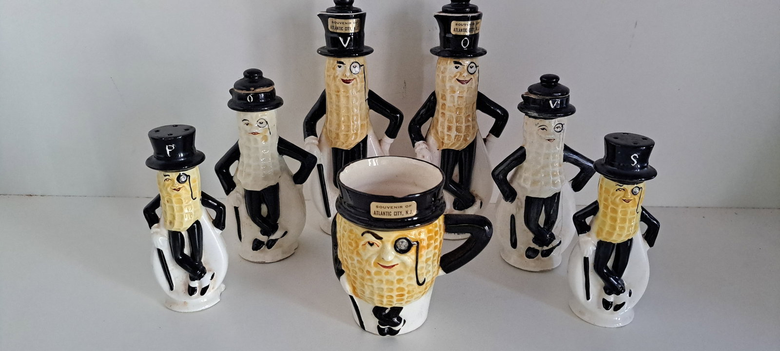 Mr. Peanut ceramic lot: Lot of early, figural Mr. Peanut ceramic oil and vinegar cruets, salt and pepper shakers, and cup with rhinestone eye. 7 pieces total. All have some chips and damage. Please see our shipping policy