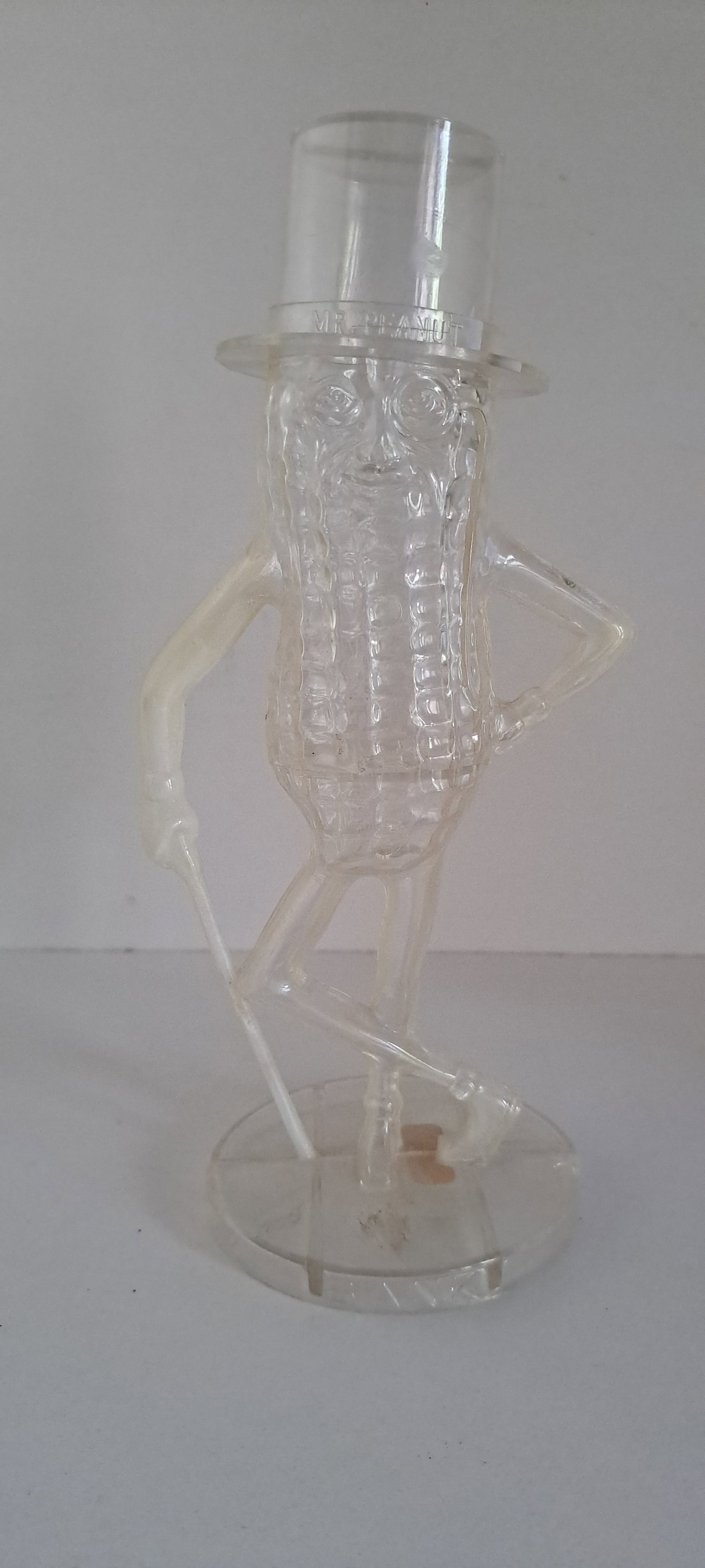 Mr. Peanut clear plastic bank: Figural, clear, plastic, Mr. Peanut coin bank. No cracks. Has some "whitening" in arms, cane, and foot. Approx. 8.5" tall. Please see our shipping policy for options.