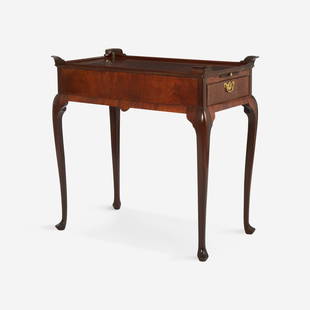 A George II carved mahogany silver table England, mid-18th century: A George II carved mahogany silver table England, mid-18th century Dished rectangular top with raised corners, over two long drawers, each below a candle slide, shaped apron, raised on slender