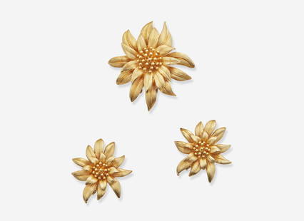 A 14K Yellow Gold Cartier Jewelry Suite: A 14K Yellow Gold Cartier Jewelry Suite A suite of jewelry by Cartier, including a brooch and matching pair of ear clips, each piece crafted from textured 14K yellow gold to depict a flower in bloom.