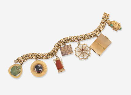 A 14K Yellow Gold Charm Bracelet: A 14K Yellow Gold Charm Bracelet A 14K yellow gold charm bracelet, with seven charms including an 18K yellow gold and beryl turtle charm, a 14K yellow gold charm depicting a dog, an 18K yellow gold la