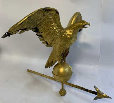 Eagle Weathervane gold leaf eagle with arrow tip on: gold leaf eagle with arrow tip on ball, gold flaking, feather bent, wings dented. Approx 28" wingtip to wingtip, Approx 23" Tall On Base