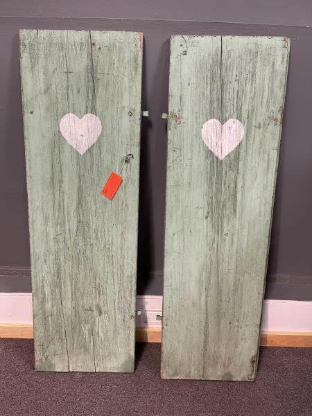 Pair of Shutters, green with white heart, iron: green with white heart, iron hardware, holes and splits, surface is rough with paint flaking, 56 1/2" x 18" w