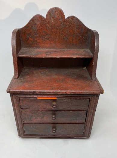 Miniature Hutch Red paint, 3 drawers graduated, round: Red paint, 3 drawers graduated, round pulls, 1 piece pine back board, 4 applied feet, 1 foot missing 1/2, nicks, rough finish throughout, molded front, 15" tall x 9" x 5" deep