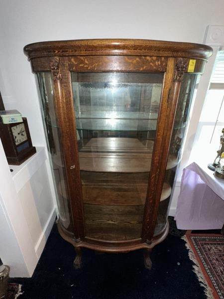 China Closet, round oak, carved lion faces: China Closet, round oak, carved lion faces, claw feet, 2 wooden shelves, one glass shelf with key, 2 sectional mirrored back - mirror is badly damaged, 61"Tx41"Wx14"D