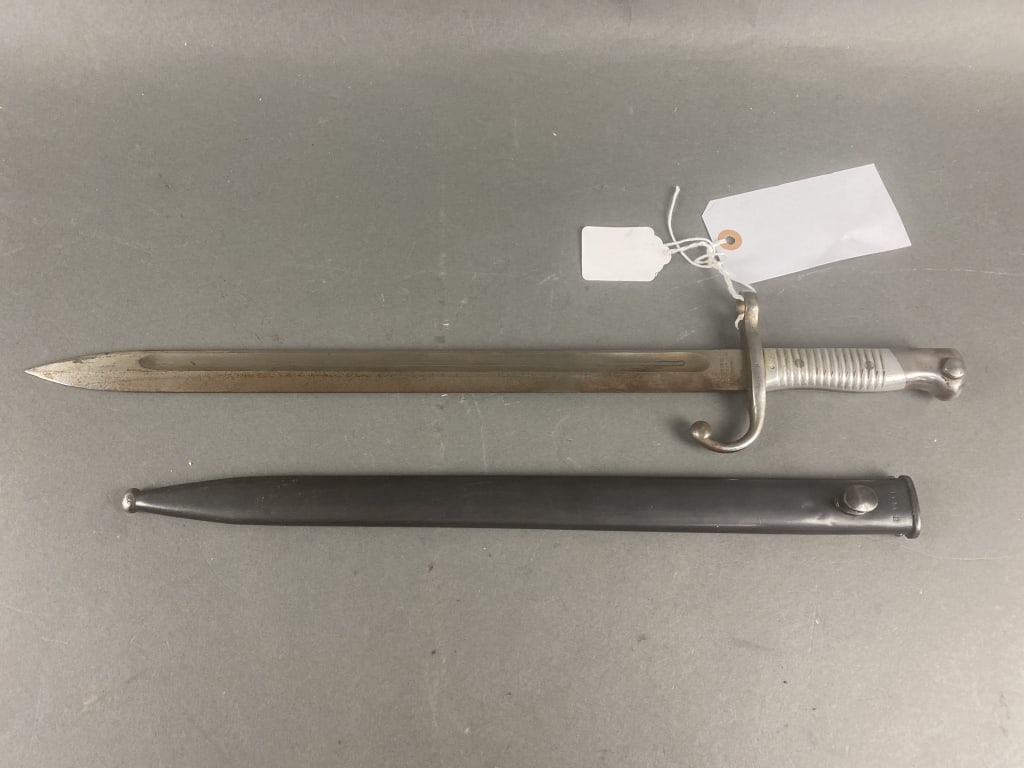 Model 1891 Argentine Bayonet WKC: Bright blade/Blued scabbard 90% finish. Excellent condition. Mismatched serial numbers. Alloy handle. Ground crestSerial number-H3540