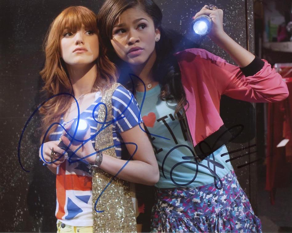 Zendaya / Bella Thorne SHAKE IT UP In Person Signed: Zendaya / Bella Thorne in person signed autographed photo from the Disney series SHAKE IT UP. Zendaya as the character Rocky Blue. Bella Thorne as the character CeCe Jones. Photo size is 8 x 10