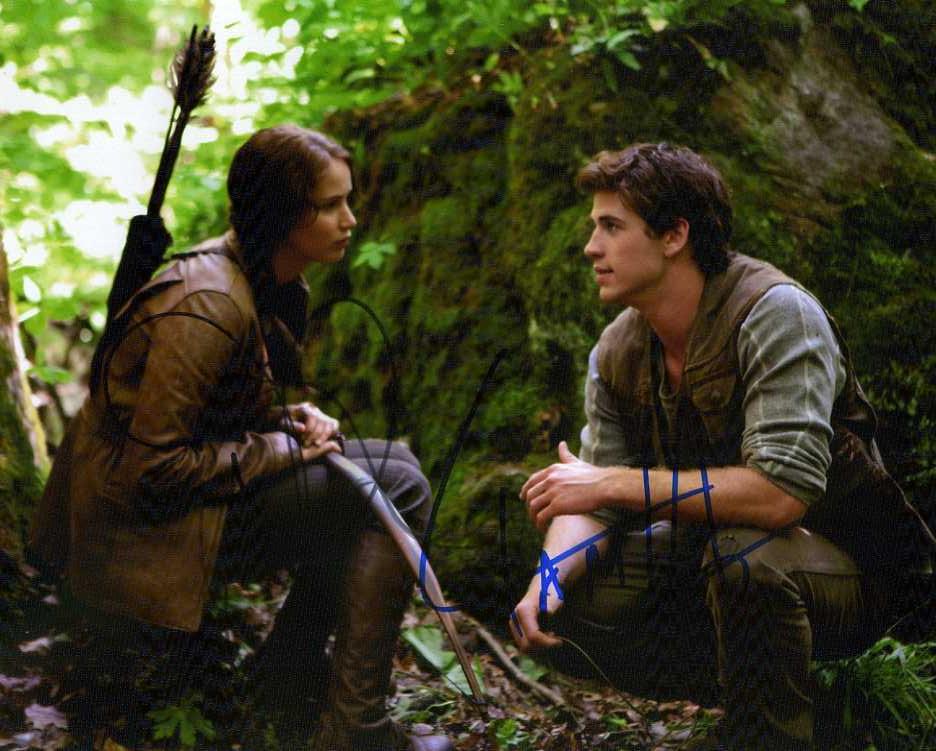 Liam Hemsworth / Jennifer Lawrence HUNGER GAMES In: Amazing in person signed photo signed by both Jennifer Lawrence and Liam Hemsworth from the movie THE HUNGER GAMES