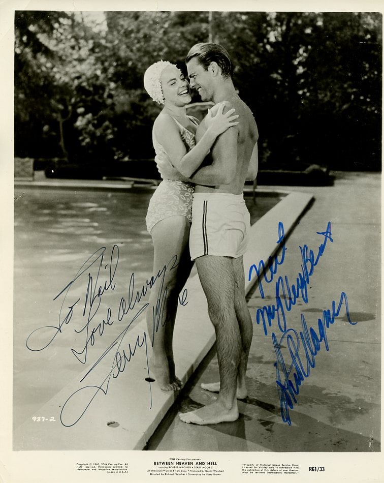 Robert Wagner / Terry Moore BETWEEN HEAVEN AND HELL Signed Photo: Photo size is 8x10. Robert Wagner / Terry Moore signed photo from the movie BETWEEN HEAVEN AND HELL. Robert Wagner as the character Pvt. Sam Francis Gifford. Terry Moore as the character Jenny Gifford