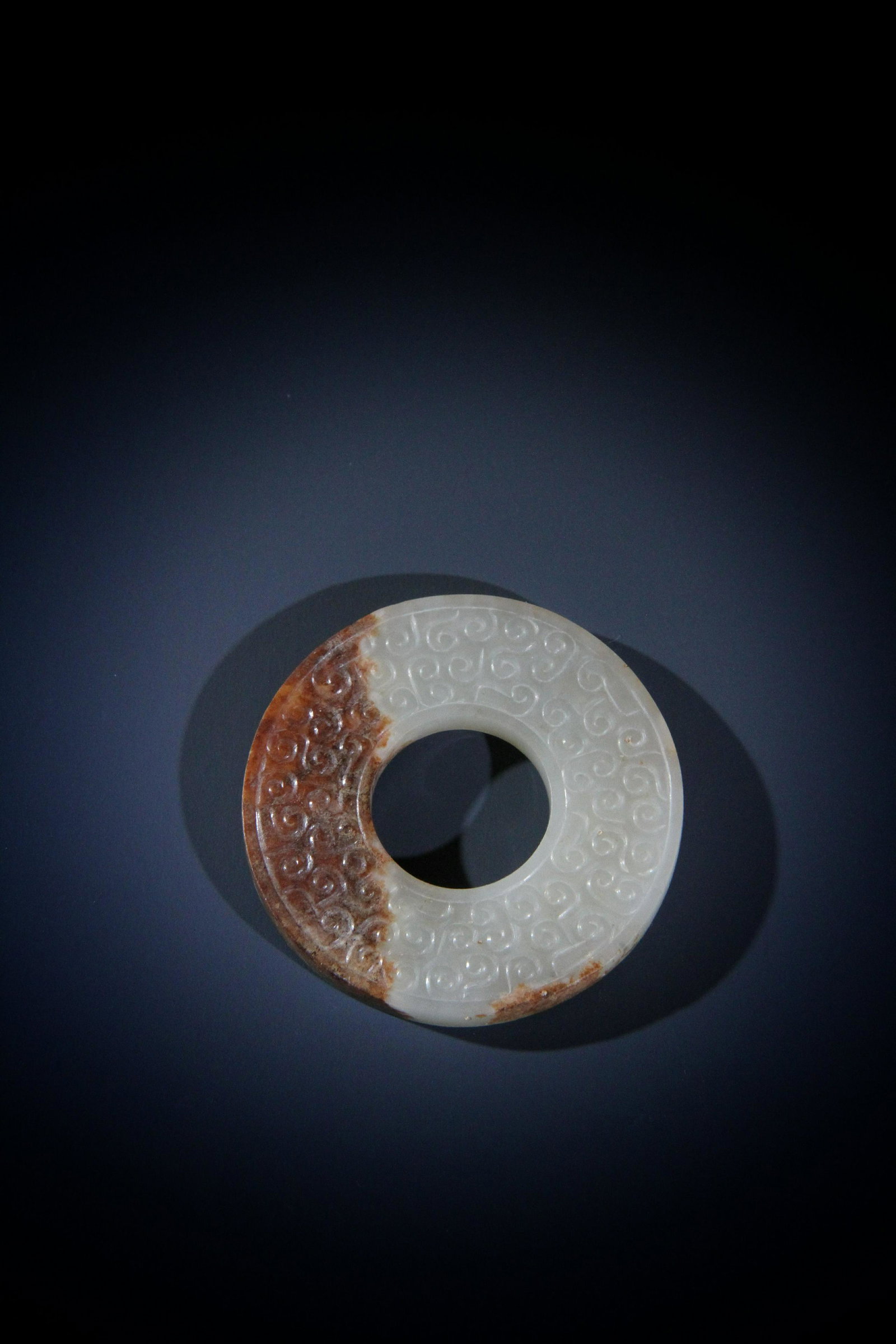 A CHINESE WHITE AND RUSSET JADE BI DISC, WARRNG STATE (1 of 3)