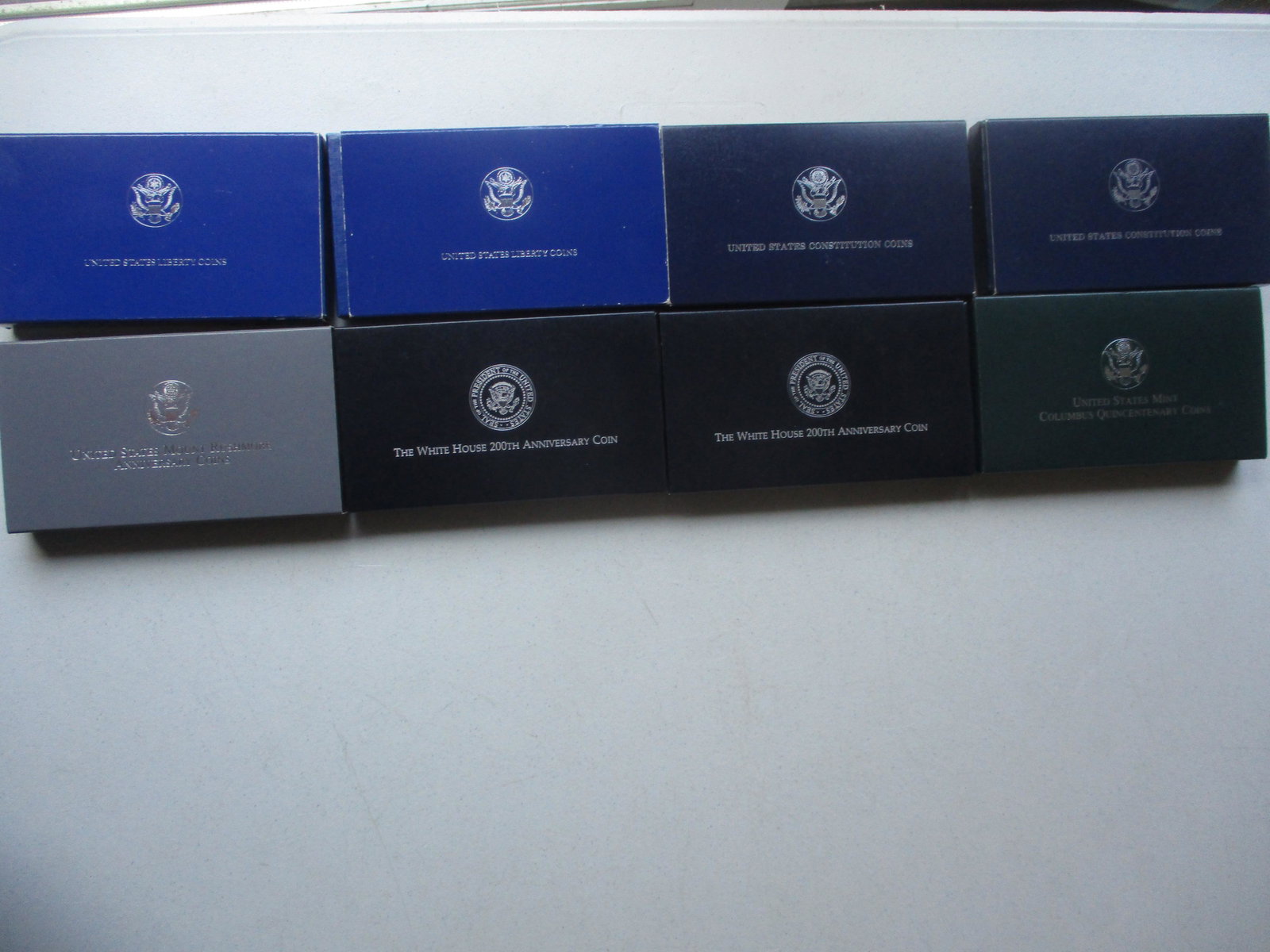 1980's and 1990's Commemorative Silver Coins: (2) 1986 Liberty 2 Coin Sets, (2) 1987 Constitution Silver Dollars (one with damaged plastic case), 1991 Mt. Rushmore 2 Coins Sets, 1992 White House, (2) 200th Anniversary Dollars, and 1992 Columbus Q