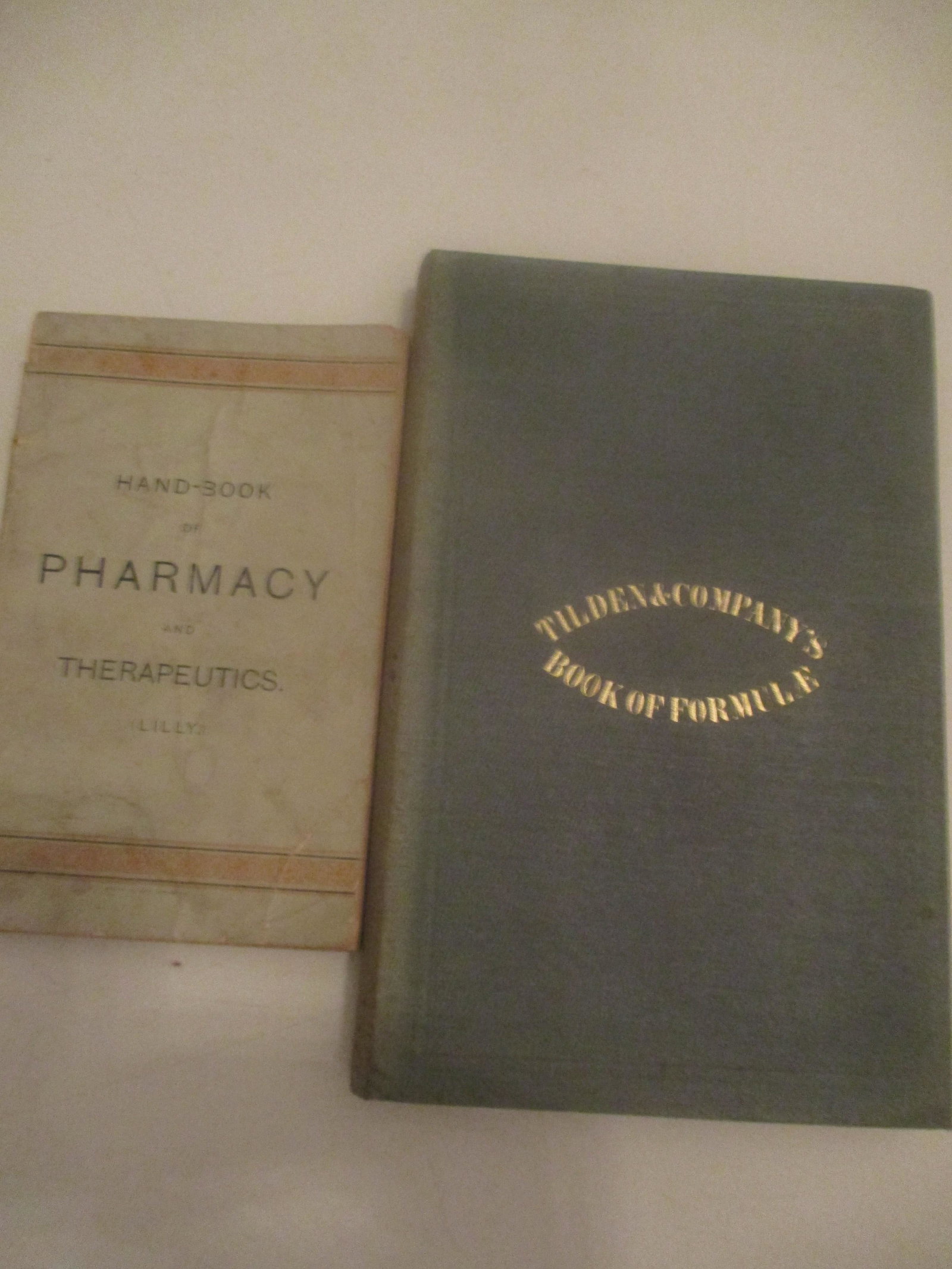 1858 Book of Formula & 1888 Handbook of Pharmacy: 1858 Tilden & Company's Book of Formula and 1888 Eli Lilly Handbook of Pharmacy and Therapeutics - Tilden book has some foxing - Lilly Softcover book has cover wear - See photos for condition and deta