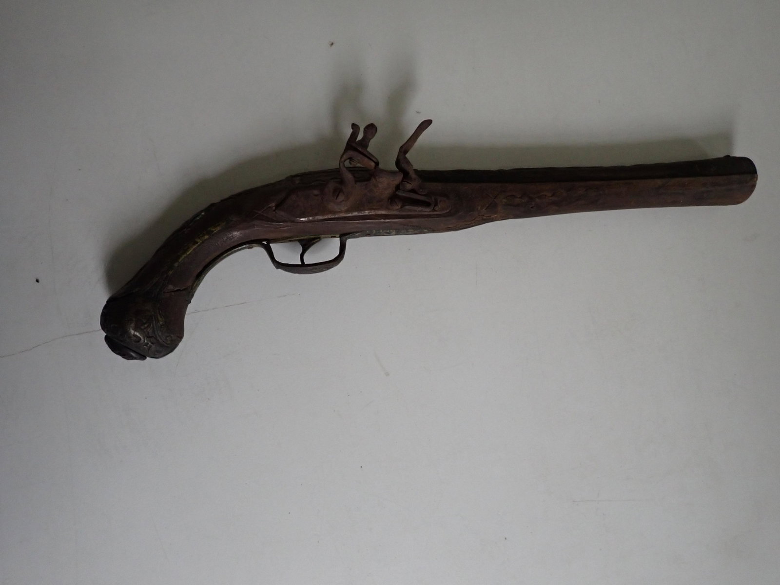 Antique Flintlock Pistol, Heavily Engraved: Metal Fittings and Trigger Guard. Wood has cracking on handle. Some rust & overall wear. Pistol is 19", Barrel is 11 1/2". See photos for condition and details.