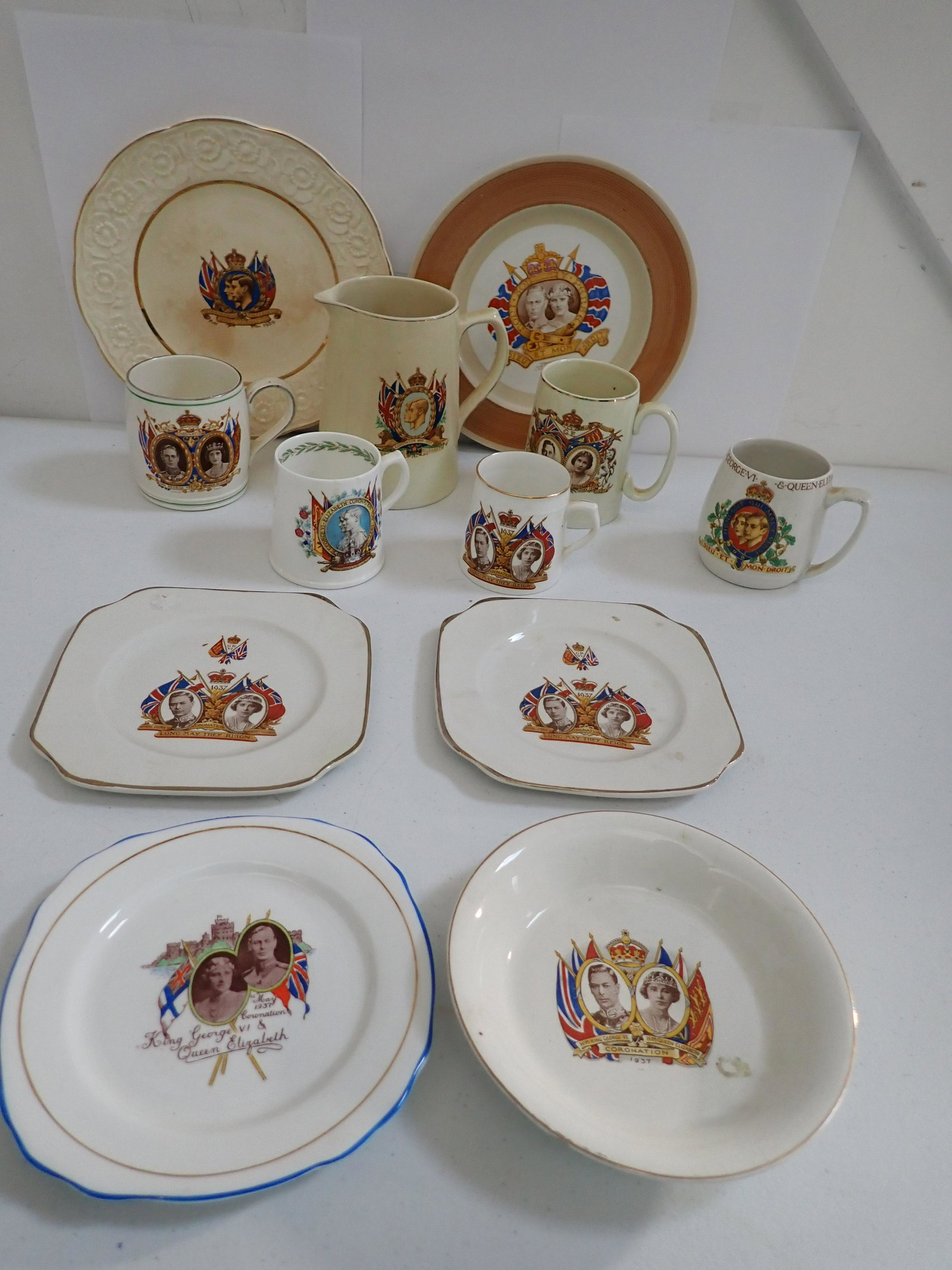 King George VI & H.M. Queen Elizabeth Coronation China, etc.: King George VI and H.M. Queen Elizabeth Coronation May 12, 1937 Souvenir China. (2) 6 3/4" Plates, (1) 6 1/4" Plate, Shelley 9" Plate, 9" Embossed Plate, Appr. 5 3/4" High Pitcher, Royal Doulton Mug 3