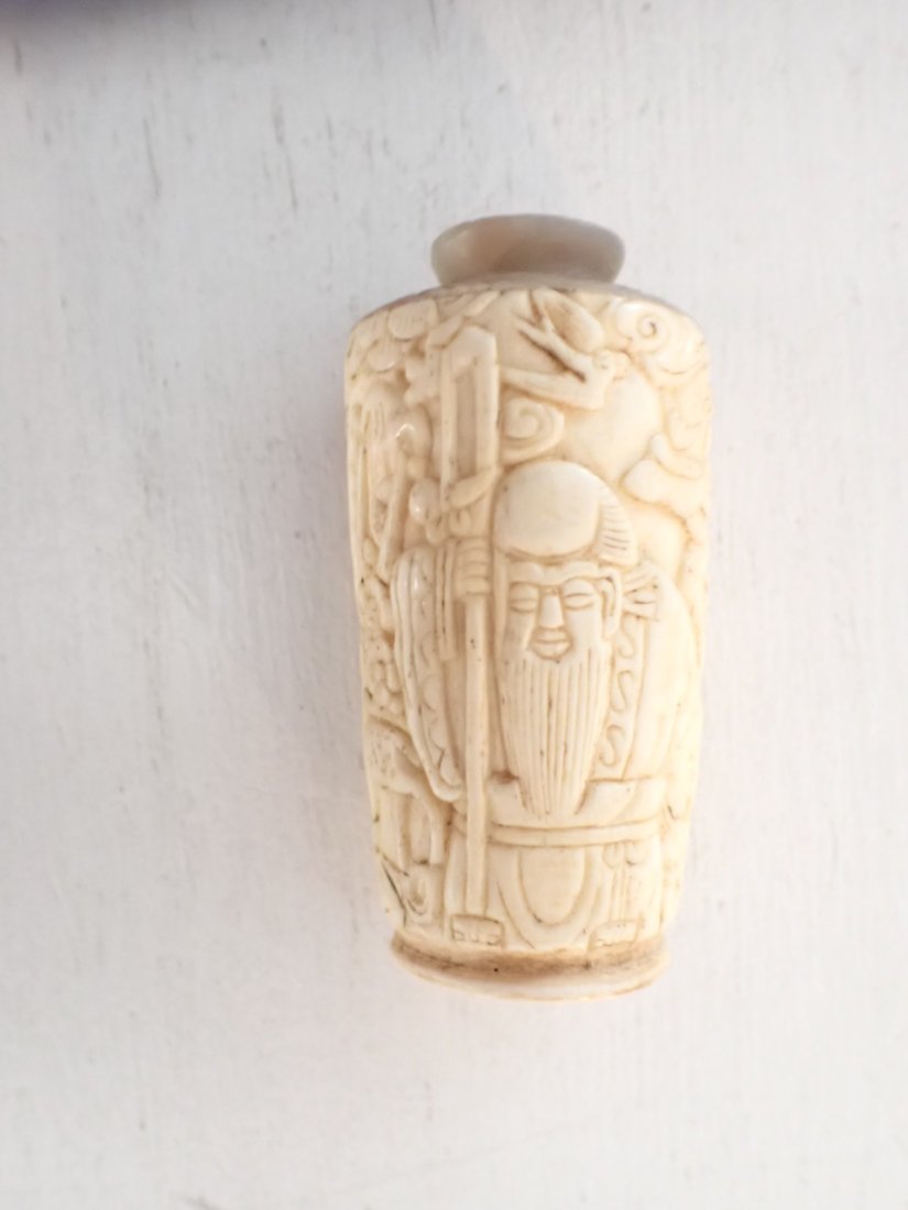 Chinese Carved Bone Snuff Bottle: Front of Bottle has Asian Man with Beard surrounded by Plants and Animals. Front of Bottle is Curved. Back has Tigers and is Flat. 2 1/2" High - No Top. See photos for condition and details. Local pic